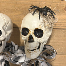Load image into Gallery viewer, Skull heads on spindles (flannel bow)
